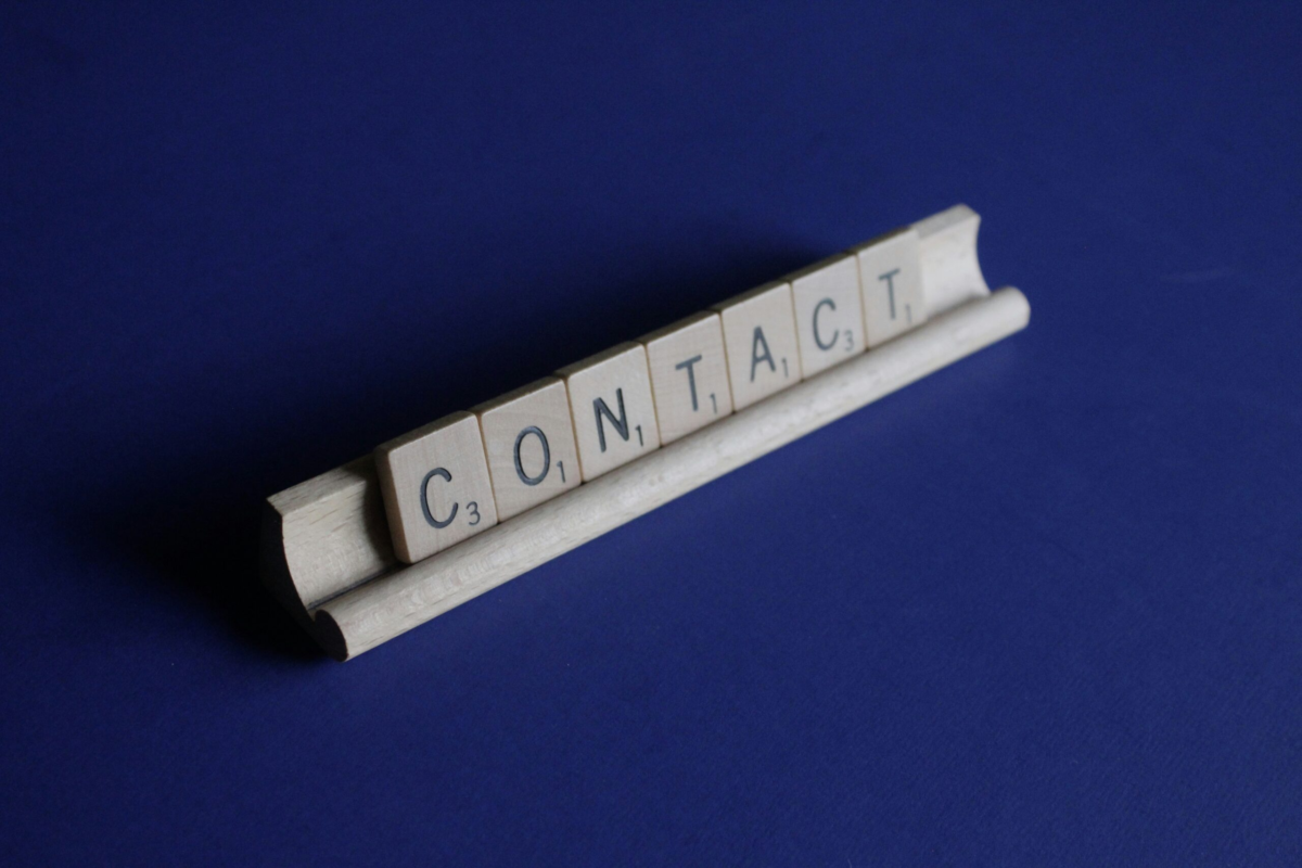 Wooden letter tiles spelling "Contact" to encourage clients to call or message Simo Massage for mobile massage appointments in Miami, Florida