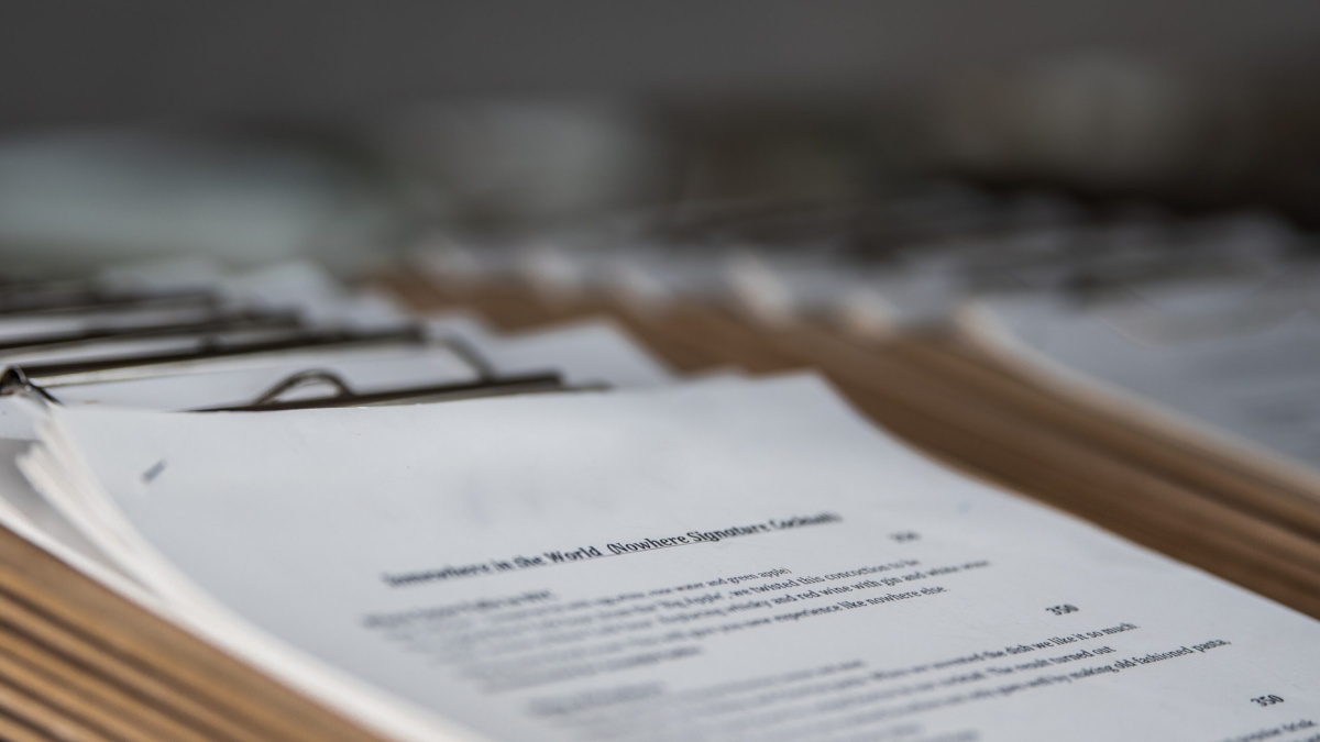 Stack of clipboards containing policy documents and client forms representing massage therapy policies, appointment guidelines, cancellations, and professional standards.