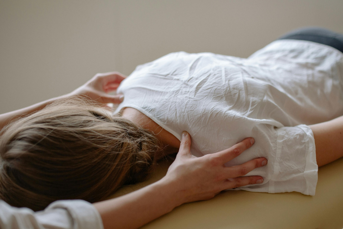 Massage therapist providing a corporate massage focused on the shoulders to relieve workplace stress, reduce muscle tension, and improve comfort and relaxation for office employees.